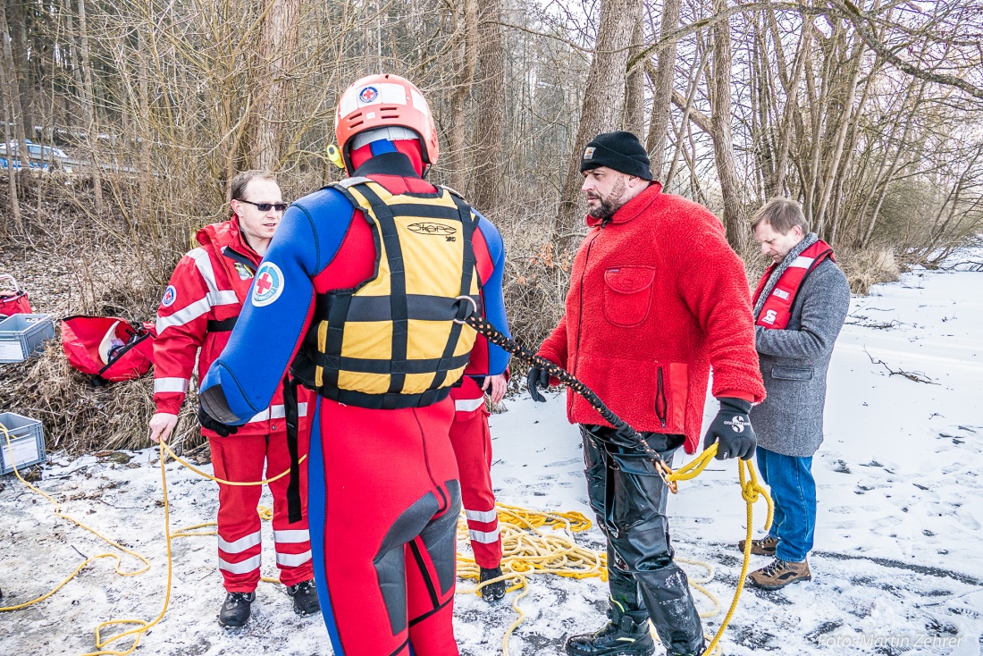 Foto: Martin Zehrer - Angeschnürt - Nur gut gesichert nähern sich die Helfer der Wasserwacht Eschenbach der im Eis eingebrochenen Person... Eigenschutz hat oberste Priorität, so Vorsitzender J 