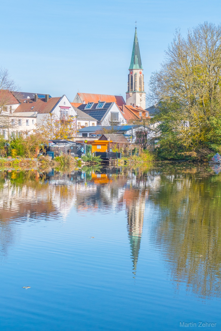 Foto: Martin Zehrer - Der Kirchturm der kemnather Kirche spiegelt sich im Stadtweiher.<br />
Ein wunderschöner Herbst-Sonntag, dieser 3. November 2024 