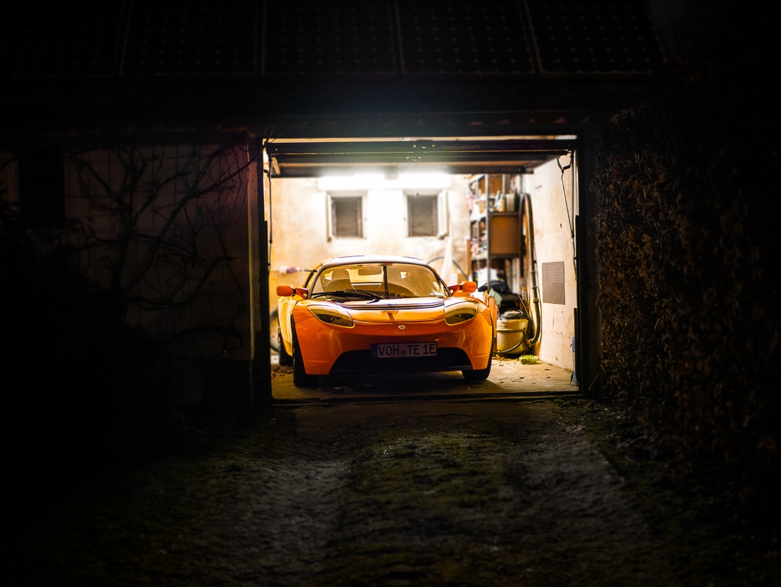 Foto: Martin Zehrer - Ein Tesla Roadster lauert in einer Garage auf die Straße -  wie ein hungriger Tiger auf seine Beute...<br />
<br />
Er ist einer von nur 2450 weltweit...<br />
<br />
Dieses Elektroauto des  